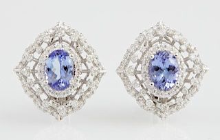 Pair of 14K White Gold Earrings, each with a 1.23 carats oval tanzanite atop a border of round diamonds and a pierced border 