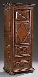 French Louis XIII Style Carved Walnut Bonnetiere, 19th c., the stepped dentillated crown over a triple panel door with geomet