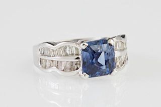 Lady's 18K White Gold Dinner Ring, with a cushion cut 3.10 carat blue sapphire, flanked by undulating shoulders mounted with 