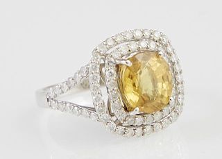 Lady's 14K White Gold Dinner Ring, with a 3.32 carat cushion cut yellow sapphire atop two pierced concentric graduated border