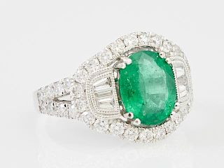 Lady's Platinum Dinner Ring, with a 2.79 carats oval emerald, flanked by six tapered diamond baguettes, within an outer borde