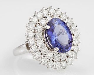Lady's 14K White Gold Dinner Ring, with an oval 6.34 carat tanzanite atop a double graduated concentric border of round diamo