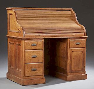American Carved Oak Roll top Desk, early 20th c., the tambour S-roll fitted with drawers and cubby holes, on a base with thre