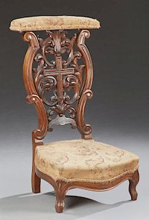 French Carved Walnut Prie Dieu, 19th c., the curved rounded armrest, over a leaf and cross backsplat, to a bowed seat, on cab