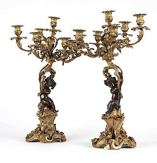 A pair of patinated and gilt bronze candelabra