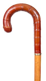 125. Alligator Dress Cane- Ca. 1950- A crook handle covered with alligator in fine condition, ¼” gold collar, honey malacca shaft and a horn ferrule. 