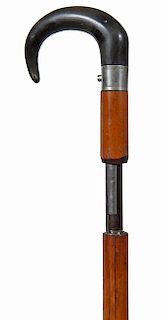 167. Shotgun Center Fire Cane- Mid 19th Century- A working shotgun cane with a nice black horn handle, original silver metal collar and trigger button