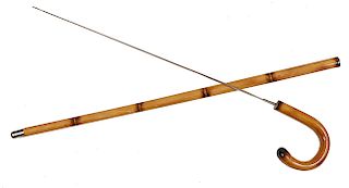200. Sword Cane- Mid 20th Century- A bamboo sword cane with a 23” two-sided blade which has a push and pull mechanism and a metal ferrule.  H.- 5” x 6