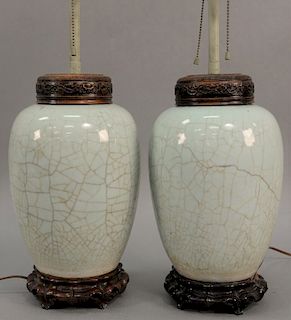 Pair of Chinese crackle glazed jars having light blue color with carved hardwood cover and stand, made into table lamps. height 24 i...