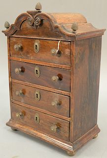 Four drawer dolls chest with bonnet top and three bronze finials. height 17 inches, width 11 1/4 inches.   Provenance: Estate of...