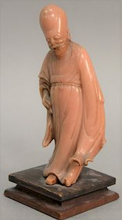 Carved pink soapstone standing scholar figure with oblong head on square wood base (as is). figure: height 7 1/2 inches, total: heig...