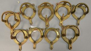 Seven brass rein racks. height 2 5/8 inches.   Provenance: Estate of Peggy & David Rockefeller having stamp/label.