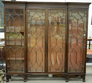 George III mahogany bookcase having blind carving over four glazed doors on short blind carved squared legs and interior adjustable...