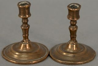 Pair of Queen Anne bell metal miniature candlesticks. height 2 inches. 

Provenance: Estate of Peggy & David Rockefeller having stam...