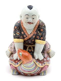 A Chinese Polychromed Porcelain Figure of a Boy Riding a Turtle Height 15 inches.
