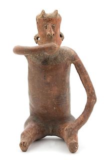 A Nayarit Slip Painted Ceramic Seated Male Figure Height 15 1/4 inches.