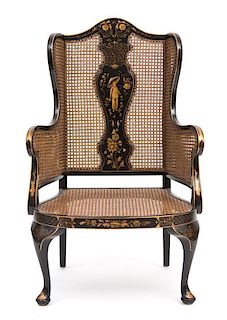 A Regency Style Black and Gilt Chinoiserie Decorated Caned Wing Chair Height 50 inches.