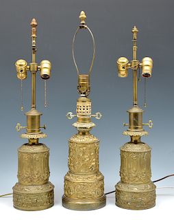 Three floral and figural repousse brass lamps