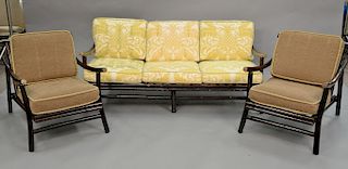 Five piece lot to include chocolate finished rattan couch (lg. 64in.), two lounge chairs, and two side tables.