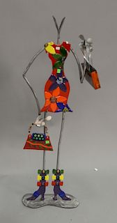 Contemporary metal and colored glass figure of woman with pocketbook. ht. 44in.