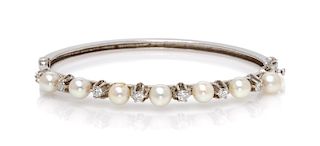 A 14 Karat White Gold, Diamond and Cultured Pearl Bangle Bracelet, 8.80 dwts.