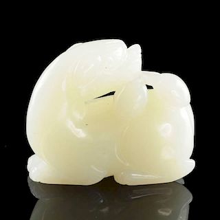 A CHINESE CARVED WHITE/PALE GREEN JADE FIGURE OF A RECUMBENT DRAGON, 20TH CENTURY,