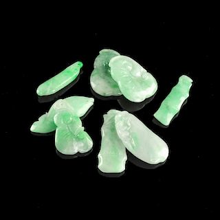 A GROUP OF EIGHT CHINESE CARVED APPLE GREEN FLECKED JADEITE PENDANTS,