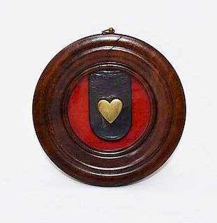 Brass heart on a leather strap framed
