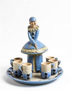 A Ceramic Figural Decanter and 6 Cups, with a Charger Height of decanter 10 inches