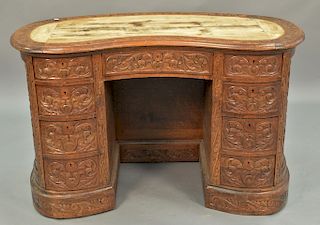 Oak kidney shaped desk, overall carved (leather writing surface missing). ht. 30in., wd. 47in.