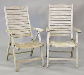 Eight teak armchairs with adjustable backs.