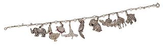 * An Art Deco White Gold, Cultured Pearl, Diamond, Ruby and Polychrome Enamel Charm Bracelet with 9 Attached Charms, 9.50 dwts.