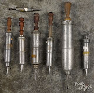 Seven pewter enema syringes