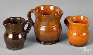 Three miniature redware pitchers
