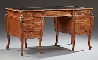 French Louis XV Style Carved Walnut Desk, 19th c., the stepped serpentine top with a gilt inset leather writing surface flanked by matching pull out s