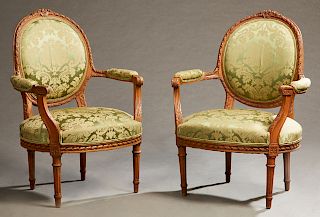 Pair of French Louis XVI Style Upholstered Beech Fauteuils, early 20th c., the medallion backs flanked by upholstered arms, to bowed seats, on turned 