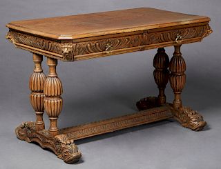 French Henri II Style Carved Oak Writing Table, c. 1880, the stepped canted corner top over a gadrooned skirt with figural masks at the corners, on ri