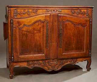French Provincial Carved Walnut Bultoir Sideboard, 18th c., with a rounded corner stepped top with lifting lid over interior storage above double arch