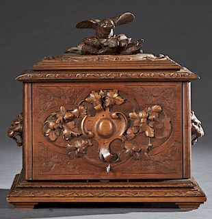 French Black Forest Style Carved Walnut Cave a Liqueur, late 19th c., the lid with a high relief carved sparrow on leaves, over a folding front carved