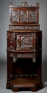 French Gothic Style Carved Walnut Cabinet, 19th c., Brittany, the arched shield crest flanked by dolphin fish and eagle finials, over a back with figu