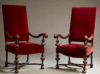 Pair of William and Mary Style Carved Walnut Open Armchairs, early 20th c., the rectangular back over scrolled arms on urn supports, to a trapezoidal 
