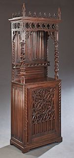 French Carved Oak Gothic Style Cupboard, 19th c., the trefoil and crocket crest over a pierced quatrefoil gallery, on rope twist supports backed by li