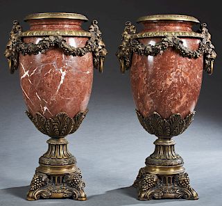 Pair of Bronze Ormolu Mounted Red Marble Urns, 20th c., the bronze rim over a ring mounted with lions head ring handles joined by floral garlands, on 