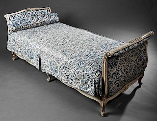 Louis XV Style Carved Polychromed Daybed, 20th c., the upholstered sleigh ends joined by relief decorated wood rails, in blue velvet foliate upholster