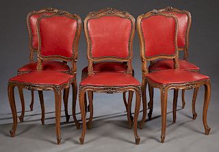 Set of Six French Louis XV Style Carved Walnut Dining Chairs, 20th c., the scroll carved arched backs on reeded cabriole legs with toupie feet joined 