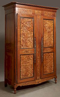 French Louis XV Style Carved Walnut and Elm armoire, 19th c., the stepped ogee canted corner crown above two burled double paneled doors with long iro