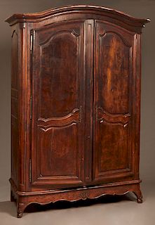 Large French Provincial Carved Walnut Armoire, c. 1820, the stepped arched crown over two double panel doors with iron escutcheons and iron fiche hing