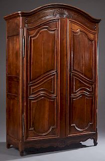 French Louis XV Style Carved Walnut Armoire, 19th c., the stepped arched rounded corner crown over two arched triple fielded panel doors with steel es