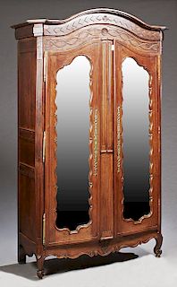 French Louis XV Style Carved Walnut Armoire, 19th c., the arched canted corner crown over double mirror doors, with long brass escutcheons and triple 