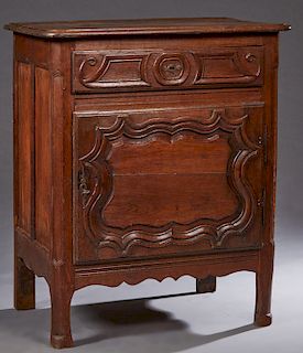 French Provincial Carved Oak Confiturier, 19th c., the stepped rounded edge and corner top over a frieze drawer and a fielded panel cupboard door with